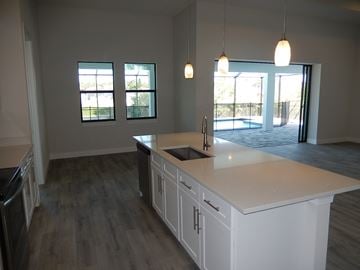 Cape Coral house for rent - an open kitchen with a large counter top and a sink