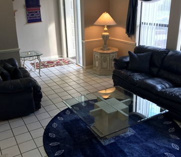 Fort Myers house for rent - a living room with couches and a glass table