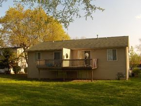 Grand Rapids apartment for rent - A house with a balcony and a tree in the background.