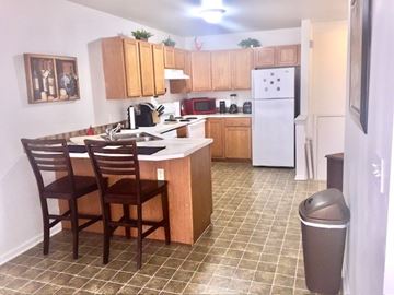 Grand Rapids apartment for rent - A kitchen with a white refrigerator and brown chairs.
