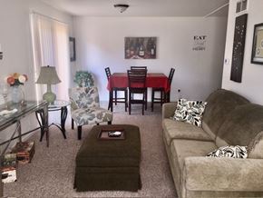Grand Rapids apartment for rent - A living room with a couch, chairs, and a dining table.