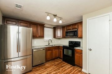 Fort Worth house for rent - A kitchen with wooden cabinets and a refrigerator.