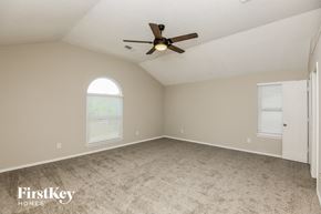 Fort Worth house for rent - A spacious room with a ceiling fan and two windows.