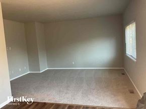 Commerce City house for rent - A room with a carpet floor and a window with blinds.