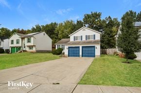 Columbus house for rent - a white house with a blue garage door and a lawn