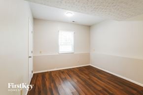 Columbus house for rent - a bedroom with wood floors and white walls and a window