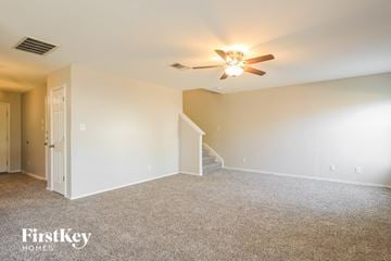 San Antonio house for rent - a spacious living room with carpet and a ceiling fan