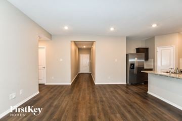 Fate house for rent - a living room with a kitchen and a stainless steel refrigerator