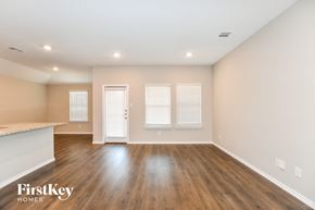 Fate house for rent - an empty living room with wood flooring and a kitchen