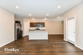Fate house for rent - a kitchen with a white island and a stainless steel refrigerator