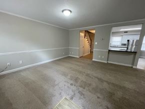 Wilson apartment for rent - A spacious room with a carpeted floor and a doorway leading to another room.