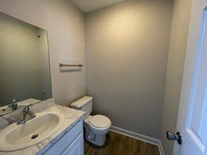 Wilson apartment for rent - A bathroom with a toilet, sink, and mirror.
