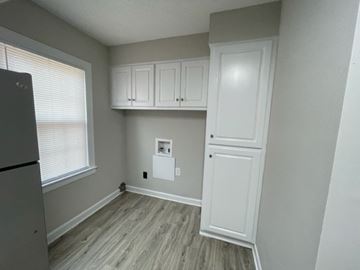 Wilson apartment for rent - A kitchen with white cabinets and a refrigerator.