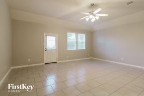 Baytown house for rent - A spacious room with a ceiling fan and two windows.