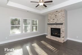 Dallas house for rent - a living room with a fireplace and a ceiling fan