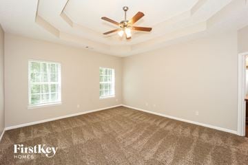 Fayetteville house for rent - a living room with carpet and a ceiling fan
