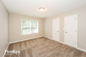 Fayetteville house for rent - a bedroom with carpet and two doors and a window