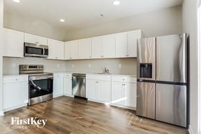 Jasper house for rent - a kitchen with white cabinets and stainless steel appliances