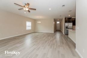 Jacksonville house for rent - A spacious room with a ceiling fan and lighting fixture.
