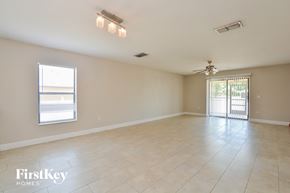 Deltona house for rent - A spacious room with a sliding glass door and a ceiling fan.