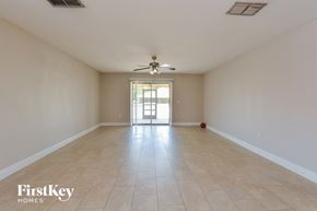 Deltona house for rent - A spacious room with a ceiling fan and tiled floor.
