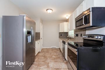 Charlotte house for rent - a kitchen with stainless steel appliances and a refrigerator