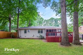 Charlotte house for rent - a small white house with a red deck and trees