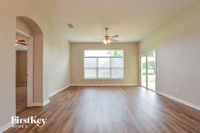 Mount Dora house for rent - A spacious room with wooden floors and a ceiling fan.