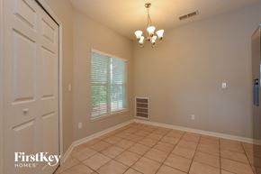 Mount Dora house for rent - A room with a chandelier, a door, and a window with blinds.