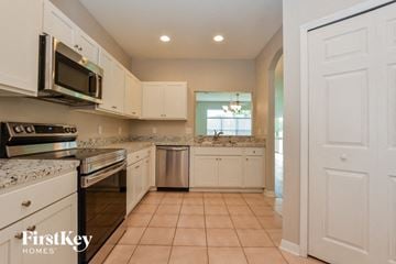 Mount Dora house for rent - A kitchen with white cabinets and appliances.