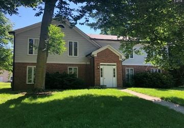 Noblesville apartment for rent - a brick house with a white door and a tree