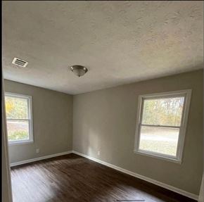 Dawsonville apartment for rent - an empty room with a hard wood floor and two windows
