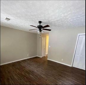 Dawsonville apartment for rent - an empty living room with a ceiling fan and wood floors