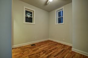Chicago apartment for rent - a empty room with wooden floors and two windows