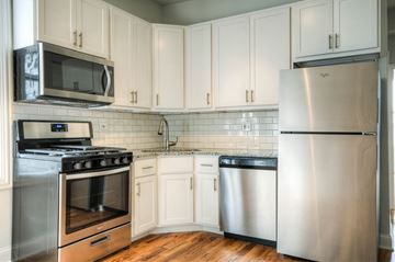 Chicago apartment for rent - a kitchen with stainless steel appliances and white cabinets