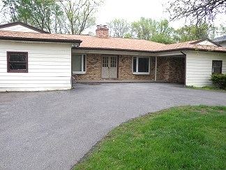 Lansing house for rent - a white house with a driveway in front of it