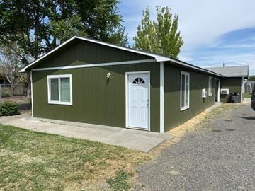Sunnyside apartment for rent - A green house with a white door and windows.