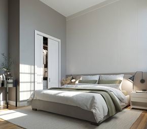 Providence apartment for rent - A modern bedroom with a large bed and a nightstand with a lamp.