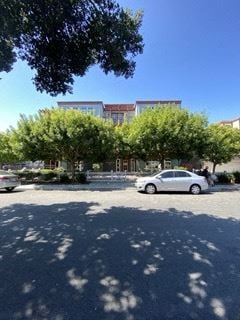 Redwood City apartment for rent - a car parked in a parking lot in front of a building