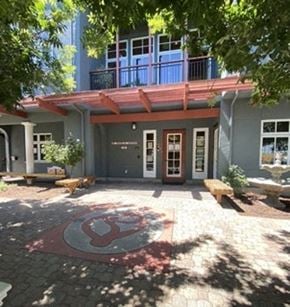 Redwood City apartment for rent - the front entrance of a blue house with a red symbol on the ground