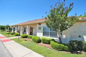 Boerne apartment for rent - a white house with a tree and a sidewalk in front of it
