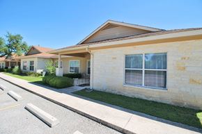 Boerne apartment for rent - a yellow house with a sidewalk in front of it