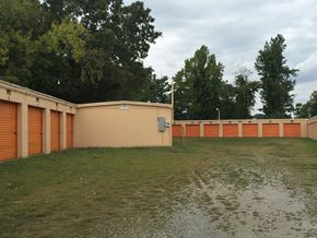 Thomasville apartment for rent - a building with orange doors and a grass field and trees