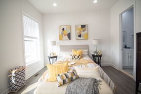 Inwood apartment for rent - a bedroom with a large bed and yellow pillows