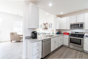 Inwood apartment for rent - a kitchen with stainless steel appliances and white cabinets