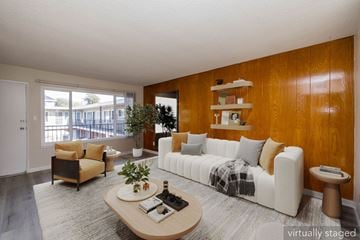 Oakland apartment for rent - A living room with a white couch and a wooden coffee table.