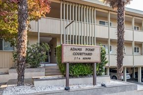 Oakland apartment for rent - A sign that says Adams Point Courtyard stands in front of a building.
