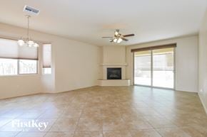 Tucson house for rent - A spacious living room with a fireplace and sliding glass doors.