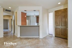 Tucson house for rent - A spacious room with a wooden door and a counter in the middle.