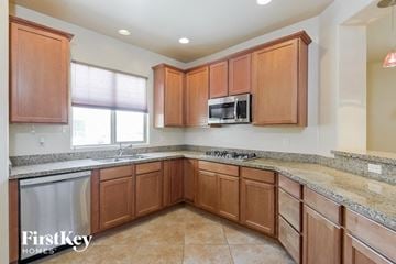 Tucson house for rent - A kitchen with wooden cabinets and a granite countertop.